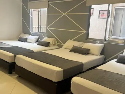 a room with three beds in a room at Hotel, Villa Real,Medellín ,Laureles,Estadio in Medellín