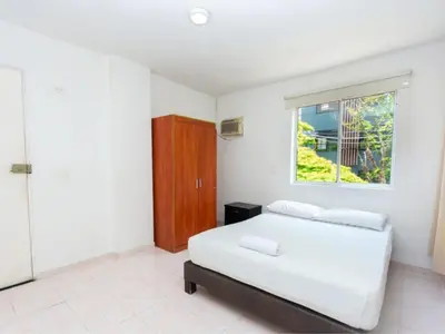 a white bedroom with a bed and a window at Hotel, Villa Real,Medellín ,Laureles,Estadio in Medellín