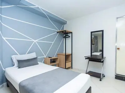 a bedroom with a bed and a mirror at Hotel, Villa Real,Medellín ,Laureles,Estadio in Medellín