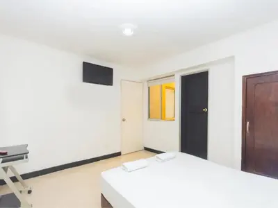 a room with two beds and a television in it at Hotel, Villa Real,Medellín ,Laureles,Estadio in Medellín