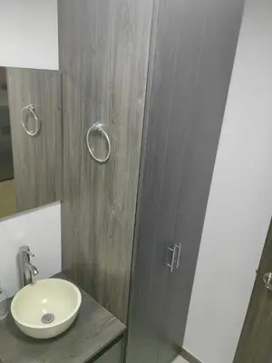 a bathroom with a sink and a wooden door at Cozy studio in Conquistadores in Medellín