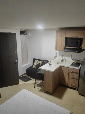 a kitchen with a sink and a couch in a room at Cozy studio in Conquistadores in Medellín