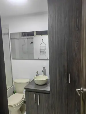 a bathroom with a sink and a toilet and a mirror at Cozy studio in Conquistadores in Medellín