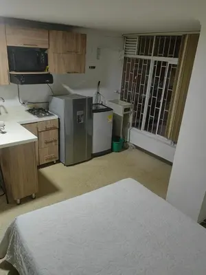 a small kitchen with a stove and a refrigerator at Cozy studio in Conquistadores in Medellín