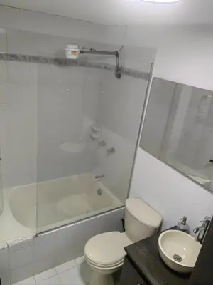a bathroom with a toilet and a shower and a sink at Cozy studio in Conquistadores in Medellín