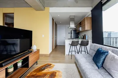 a living room with a couch and a tv and a kitchen at DISTRITO v in Estación El Salto