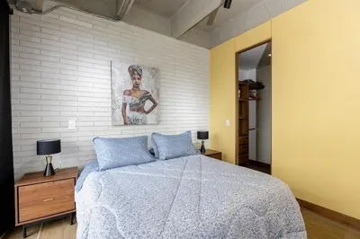 a bedroom with a bed and a painting on the wall at DISTRITO v in Estación El Salto