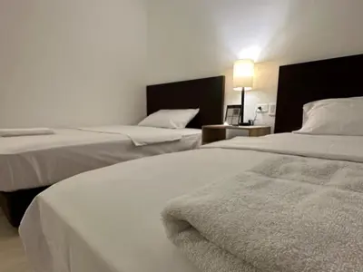 a hotel room with two beds and a lamp at Hotel Opera Medellín Entertainment, Adults Only in Medellín