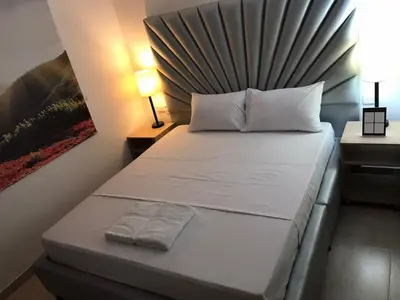 a small bedroom with a bed with a headboard at Hotel Opera Medellín Entertainment, Adults Only in Medellín