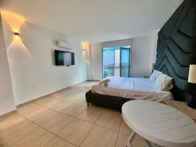 a hotel room with a bed and a table at Hotel Opera Medellín Entertainment, Adults Only in Medellín