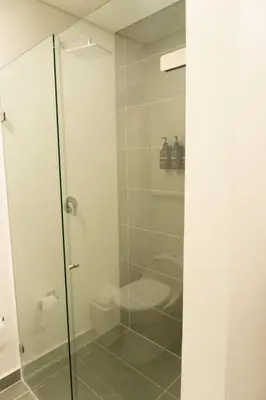 a bathroom with a toilet and a glass shower at Incredible new apartment in Envigado for six people in Envigado