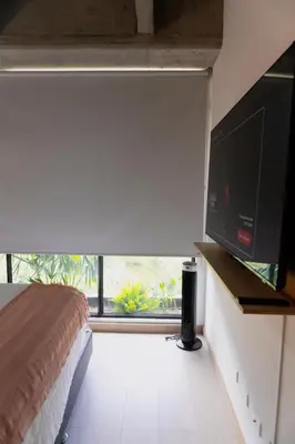 a bedroom with a bed and a flat screen tv at Incredible new apartment in Envigado for six people in Envigado