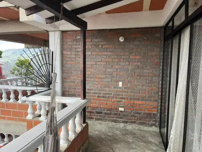 a balcony with a brick wall and a window at Hotel Montañitas in Guatapé