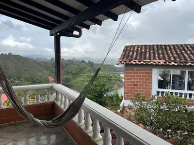 a hammock on the balcony of a house at Hotel Montañitas in Guatapé