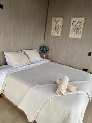 a large white bed with two towels on it at Aluna's in Guatapé