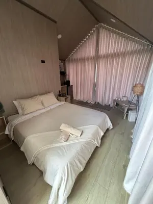 a large bed in a room with a large window at Aluna's in Guatapé