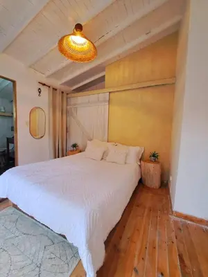 a bedroom with a white bed and a chandelier at Casa Refugio in Envigado