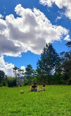 two people sitting in the grass in a field at Casa Refugio in Envigado