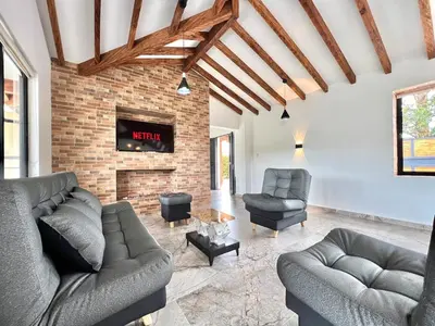 a living room with two couches and a fireplace at Casa Campestre de Lujo Familiar y Natural in Carmen de Viboral