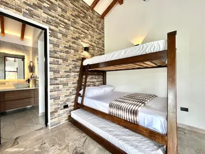 a bedroom with two bunk beds in a brick wall at Casa Campestre de Lujo Familiar y Natural in Carmen de Viboral