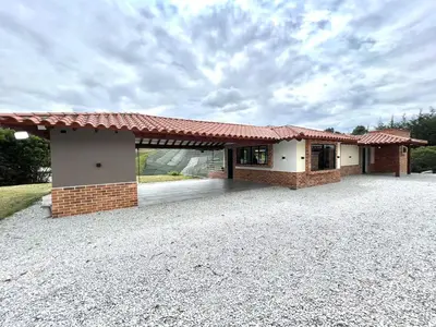 a house with a red roof on a gravel driveway at Casa Campestre de Lujo Familiar y Natural in Carmen de Viboral