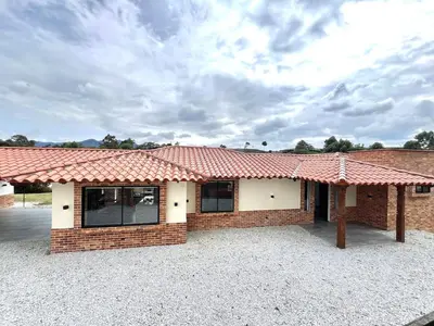 a brick house with a red roof at Casa Campestre de Lujo Familiar y Natural in Carmen de Viboral