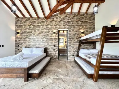 a bedroom with two bunk beds and a brick wall at Casa Campestre de Lujo Familiar y Natural in Carmen de Viboral