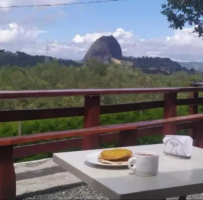 a table with a plate of pancakes and a cup of coffee at Casa de Colores in Guatapé