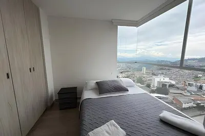 a bedroom with a bed and a large window at Lujoso con linda vista - Estrato 6 in Manizales