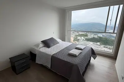 a bedroom with a bed and a large window at Lujoso con linda vista - Estrato 6 in Manizales