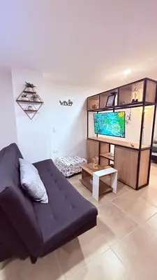 a living room with a couch and a flat screen tv at Apartaestudio completo en Itagüí - Shalom - 201 in Itagüí