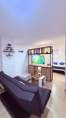 a living room with a couch and a flat screen tv at Apartaestudio completo en Itagüí - Shalom - 201 in Itagüí