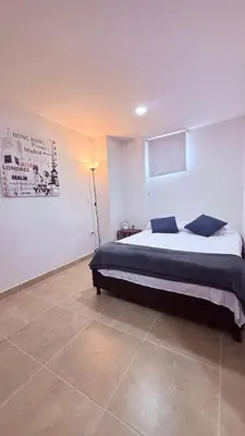 a bedroom with a bed and a lamp in it at Apartaestudio completo en Itagüí - Shalom - 201 in Itagüí