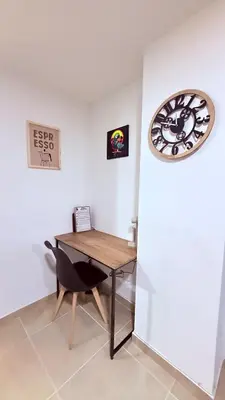 a table and a clock on a wall in a room at Apartaestudio completo en Itagüí - Shalom - 201 in Itagüí