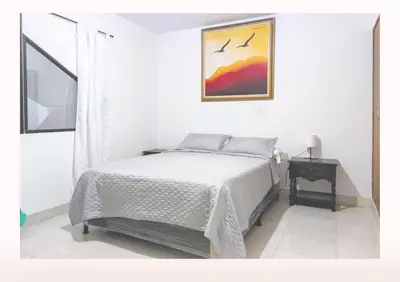a bedroom with a bed and a picture on the wall at Hostal Casa Coliving Medellín - Laureles in Medellín
