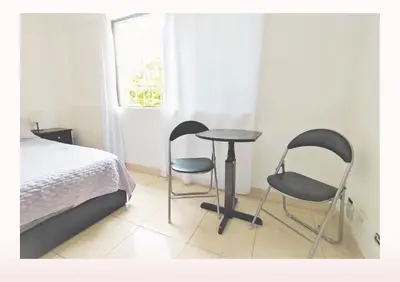 a bedroom with two chairs and a table and a bed at Hostal Casa Coliving Medellín - Laureles in Medellín