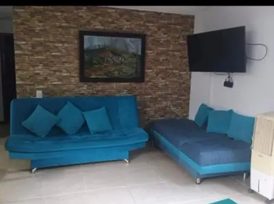 a living room with blue couches and a brick wall at Ciudadela santafe La Margarita in Santa Fe de Antioquia