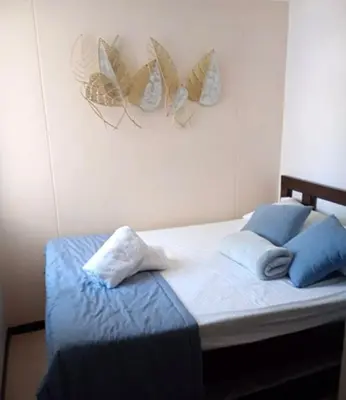 a bedroom with a bed with blue pillows at Ciudadela santafe La Margarita in Santa Fe de Antioquia