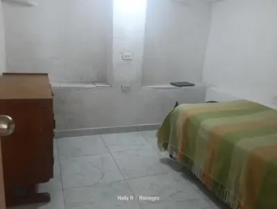 a room with two beds and a table and a window at Apartaestudio Ríonegro in Rionegro