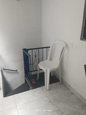 a white chair sitting in the corner of a room at Apartaestudio Ríonegro in Rionegro