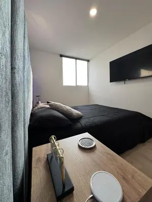a bedroom with two beds and a wooden table at Urbanity in Estación El Salto