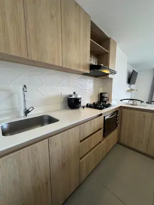 a kitchen with wooden cabinets and a sink at Urbanity in Estación El Salto