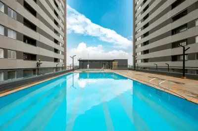 a swimming pool with blue water in a building at Urbanity in Estación El Salto