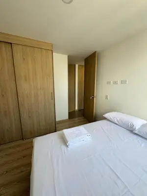 a bedroom with a white bed and wooden cabinets at Urbanity in Estación El Salto