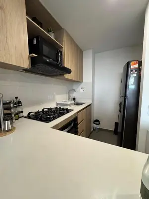 a kitchen with a stove and a black refrigerator at Urbanity in Estación El Salto