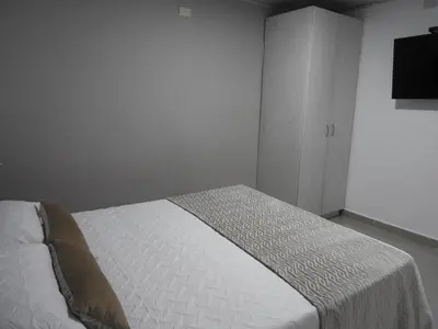a bedroom with a white bed and a cabinet at Mediterraneo Express in Medellín