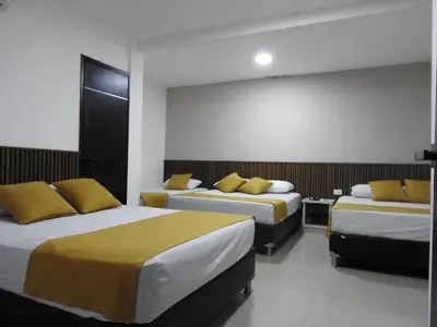 a hotel room with two beds with yellow pillows at Mediterraneo Express in Medellín