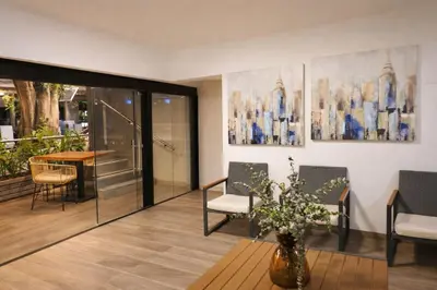 a living room with a table and chairs and a vase with flowers at Mediterraneo Express in Medellín