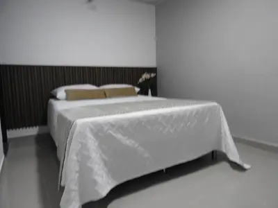 a bedroom with a bed with white sheets and pillows at Mediterraneo Express in Medellín