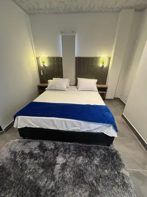 a bedroom with a large bed with blue and white sheets at aparta hotel del toro in Puerto Triunfo